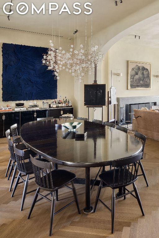 dining room with light parquet flooring and a tiled fireplace