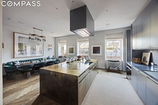 kitchen with light parquet floors, a wealth of natural light, and a large island