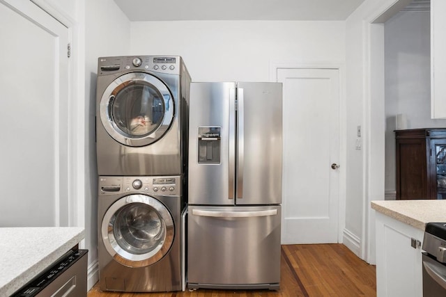 washroom featuring dark wood-type flooring and stacked washer / dryer