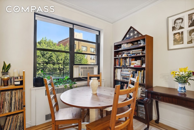 dining room featuring cooling unit, crown molding, and wood finished floors