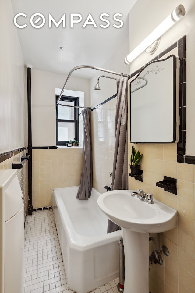 bathroom with shower / bath combo with shower curtain, tile patterned flooring, and tile walls