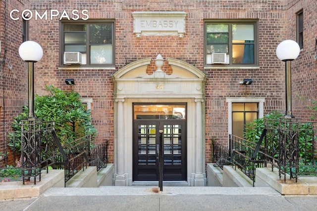 property entrance featuring french doors and brick siding