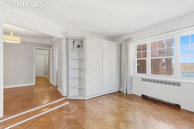 unfurnished bedroom with a closet and radiator heating unit