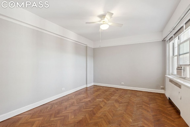 empty room with ceiling fan, radiator, and dark parquet floors