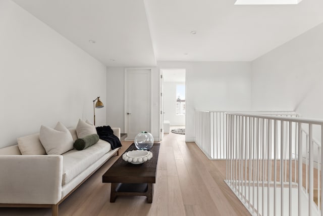 living room with a skylight and light hardwood / wood-style flooring