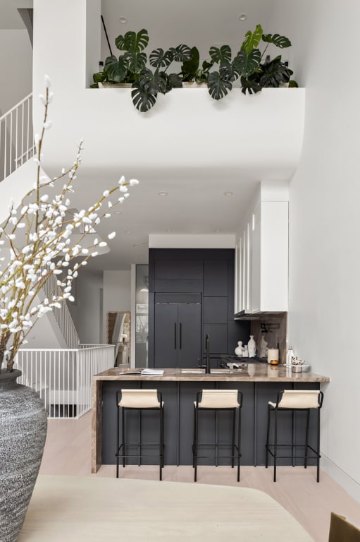 kitchen featuring a kitchen bar, white cabinetry, tasteful backsplash, sink, and light wood-type flooring