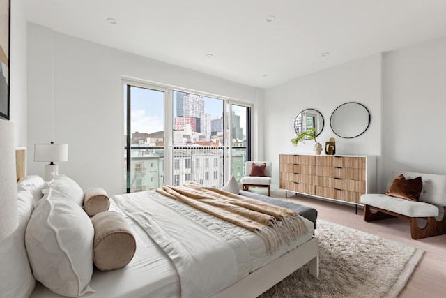 bedroom with access to exterior and light wood-type flooring