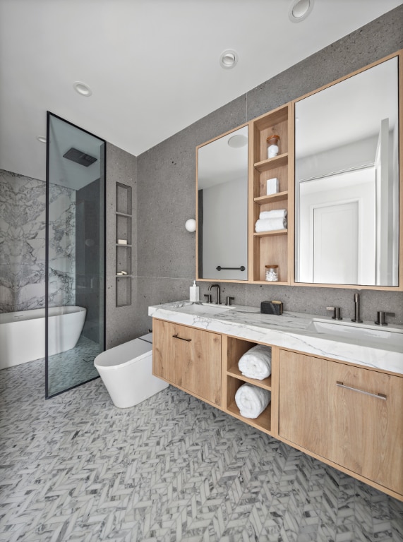 bathroom with toilet, a bathing tub, tile walls, and vanity