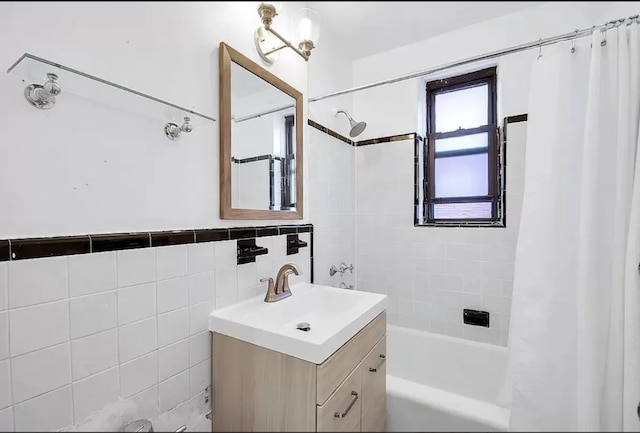 bathroom featuring tile walls, vanity, and shower / bath combo with shower curtain