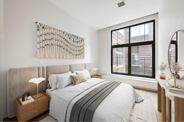 bedroom with wood-type flooring and multiple windows