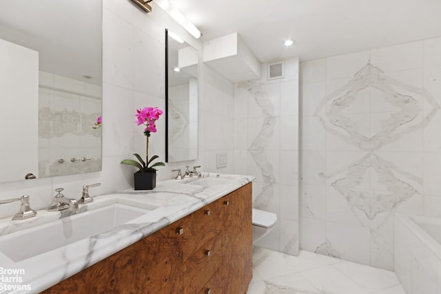 bathroom with toilet, vanity, tile walls, and a washtub