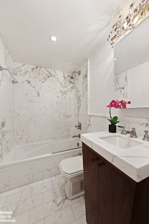 full bathroom featuring toilet, tiled shower / bath, and vanity