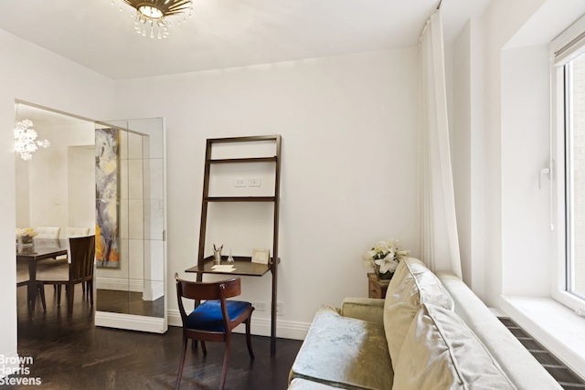 sitting room with dark parquet flooring and a notable chandelier