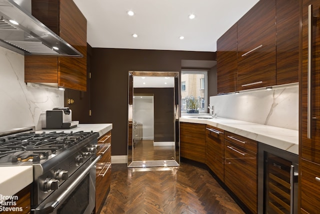 kitchen with high end stainless steel range, beverage cooler, wall chimney range hood, backsplash, and dark parquet floors