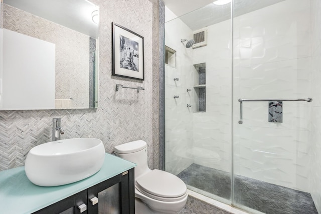 bathroom featuring toilet, a shower with door, backsplash, tile walls, and vanity