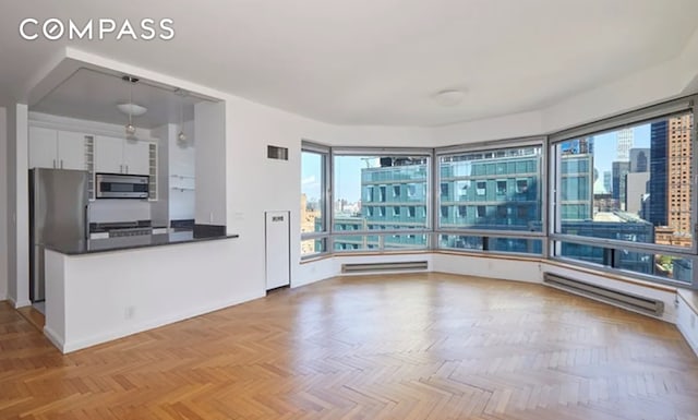 301 W 57th St Unit 22D, New York City, NY 10019 - unfurnished room with a city view and a baseboard heating unit