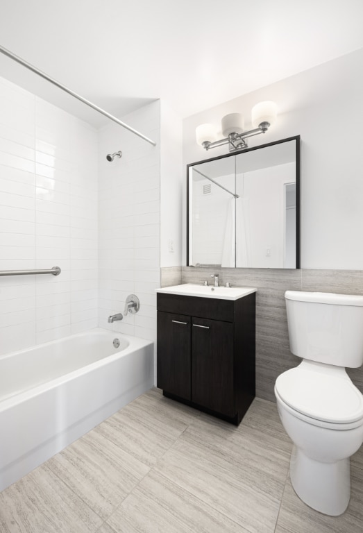 full bathroom featuring vanity, toilet, and tiled shower / bath