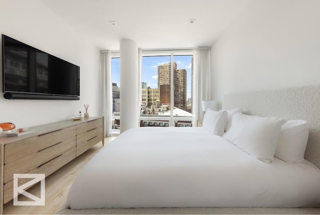 bedroom featuring light hardwood / wood-style flooring and expansive windows