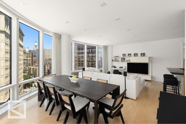 dining room with expansive windows and light hardwood / wood-style flooring