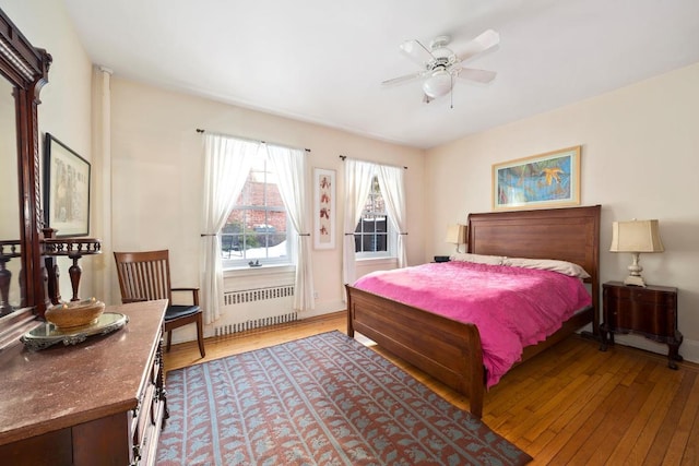 bedroom with ceiling fan, radiator, and light hardwood / wood-style floors