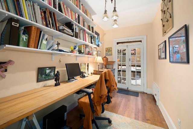 home office with hardwood / wood-style flooring and french doors