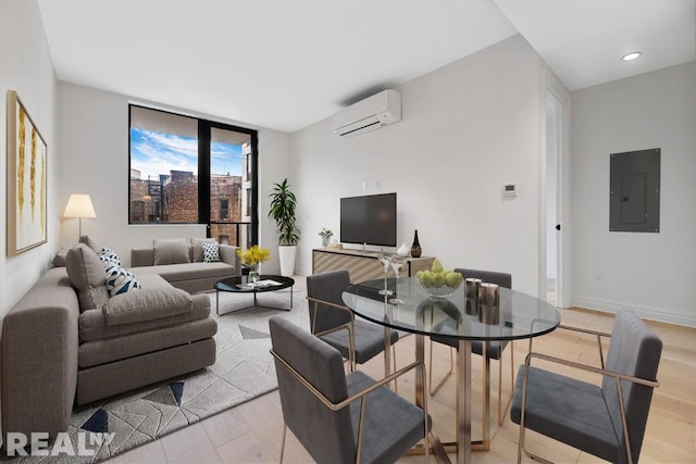 living room with a wall mounted air conditioner, electric panel, expansive windows, and light wood-type flooring