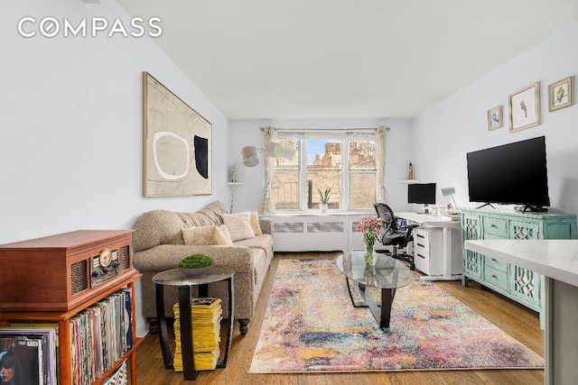 living room with radiator and light hardwood / wood-style flooring