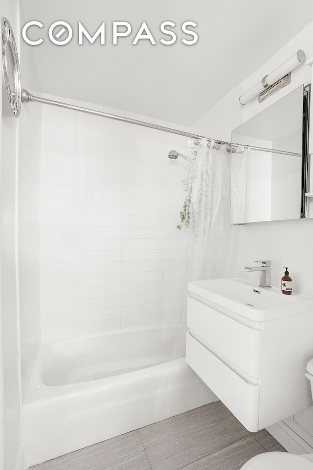 full bathroom with a sink, shower / tub combo with curtain, toilet, and tile patterned floors