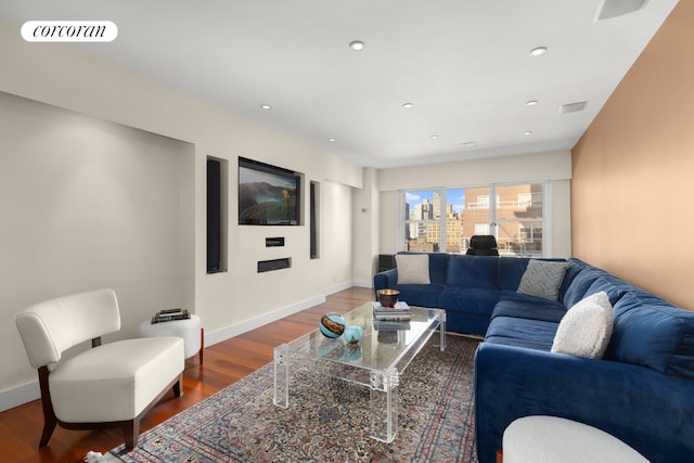 living area featuring visible vents, baseboards, and wood finished floors