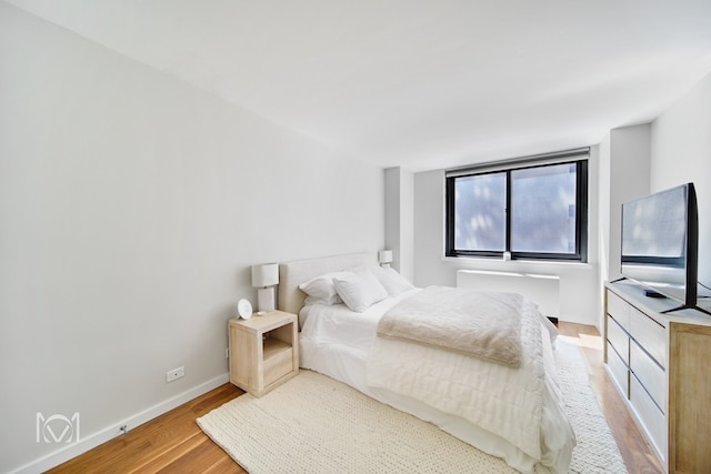 bedroom with light wood-style floors and baseboards