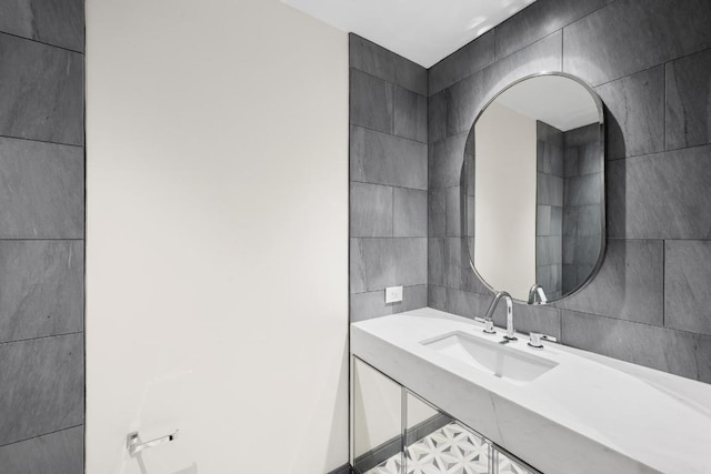 bathroom featuring tile walls and sink