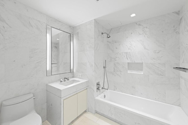 full bathroom with toilet, vanity, tile walls, tile patterned flooring, and tiled shower / bath combo