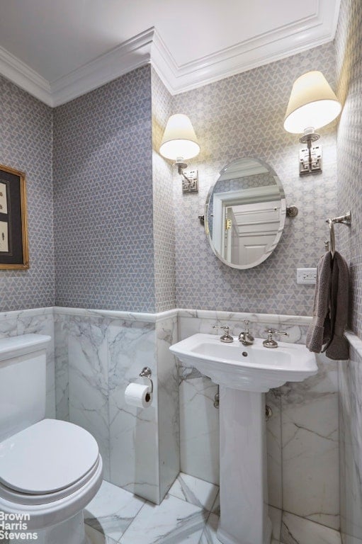 bathroom with ornamental molding and toilet