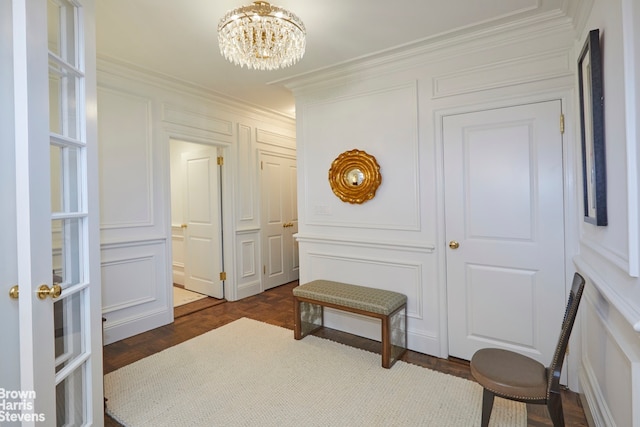 interior space featuring dark parquet flooring, ornamental molding, and a chandelier