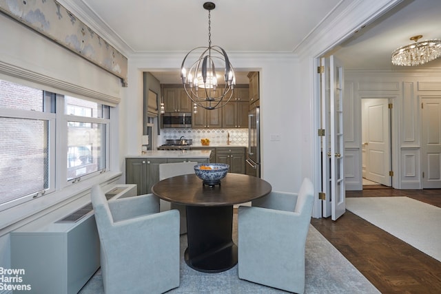 dining space featuring crown molding, dark parquet flooring, and a chandelier