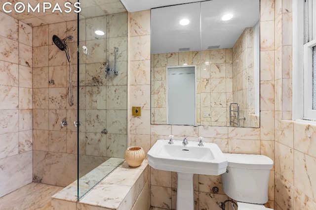 bathroom with tile walls, tiled shower, and toilet