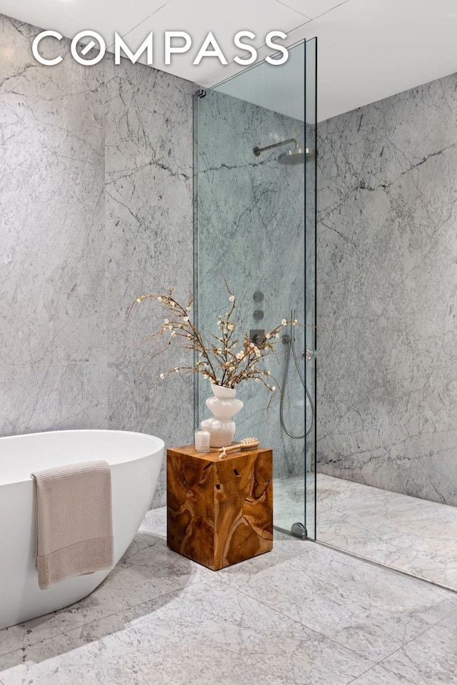 full bath with marble finish floor, a marble finish shower, and a soaking tub