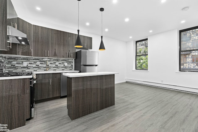 kitchen with light countertops, appliances with stainless steel finishes, dark brown cabinets, modern cabinets, and under cabinet range hood