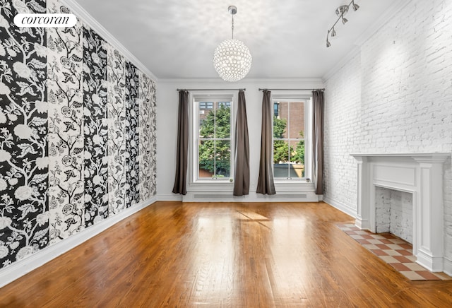 unfurnished living room featuring light wood-type flooring, ornamental molding, and a notable chandelier