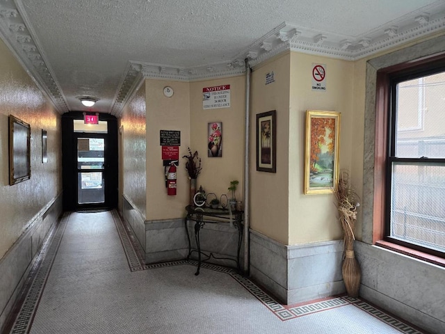 hall featuring a wealth of natural light, crown molding, and a textured ceiling