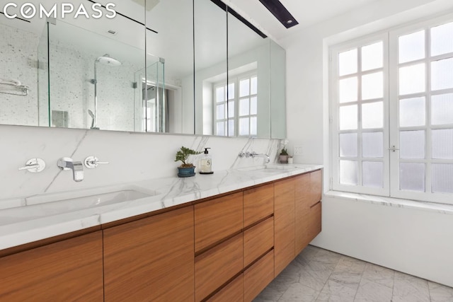 bathroom featuring a shower with shower door and vanity