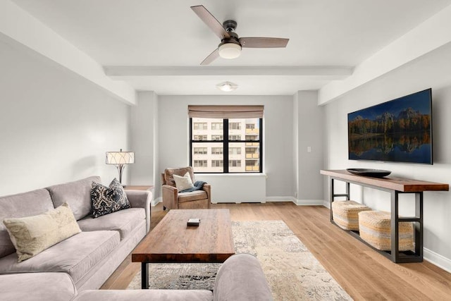 living room with beamed ceiling, ceiling fan, and light hardwood / wood-style flooring