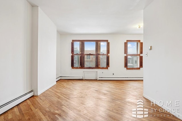 empty room with baseboard heating and hardwood / wood-style flooring