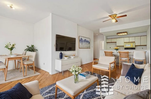 living room featuring ceiling fan and light hardwood / wood-style flooring