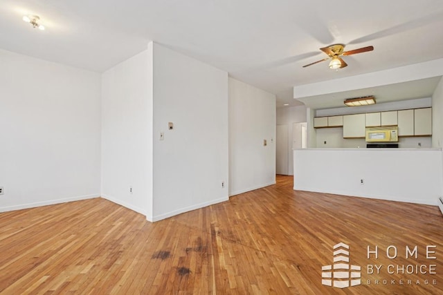 unfurnished living room with light wood-type flooring and ceiling fan