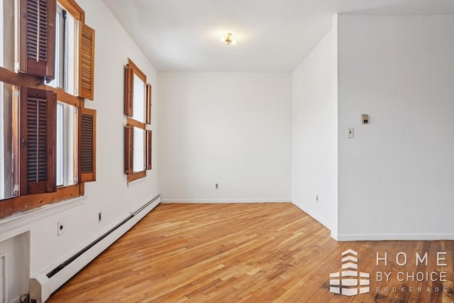 unfurnished room featuring a baseboard radiator and light wood-type flooring