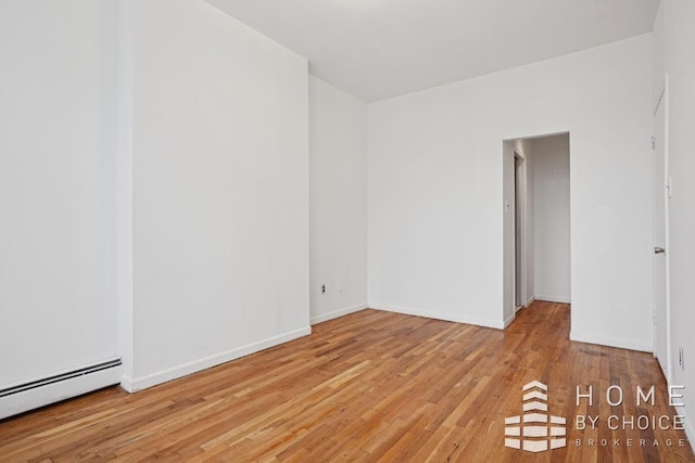 empty room featuring baseboard heating and light wood-type flooring