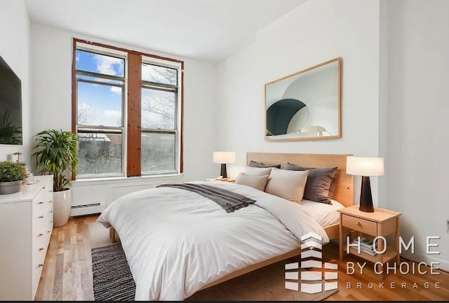 bedroom featuring light wood-type flooring and baseboard heating