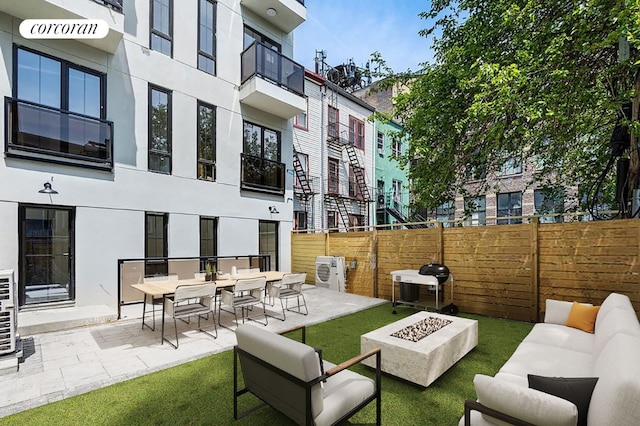 view of patio with a grill and an outdoor living space with a fire pit