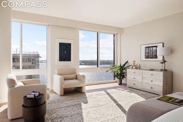 bedroom with a water view and light hardwood / wood-style flooring